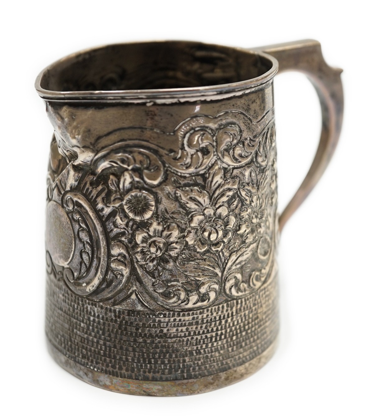 A George III silver mug, with later embossed decoration (af.), Charles Hougham?, London, 1812, height 81mm.